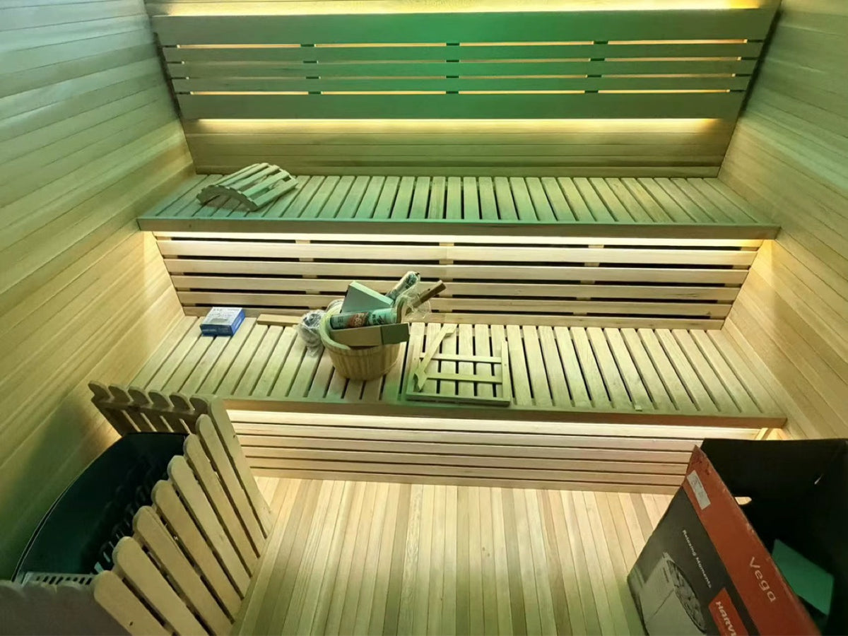 Cedar sauna interior with two-tier benches and warm lighting